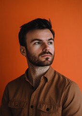 Obraz premium A man with a beard and a brown shirt is looking at the camera