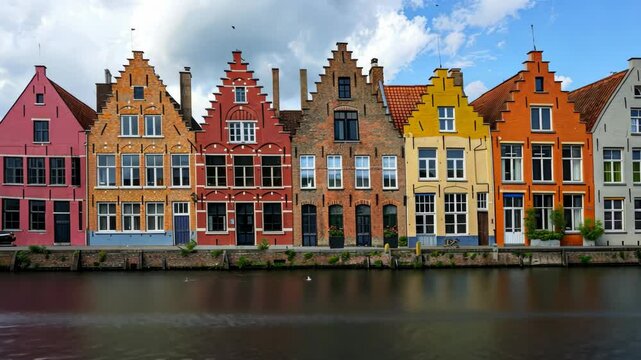 A row of colorful houses line a canal in Bruges, Belgium