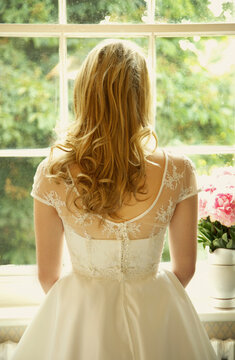 Back View of Young Bride Looking Out of Window

