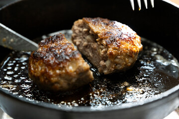 鉄板の上の熱々の焼きたてのビーフハンバーグ