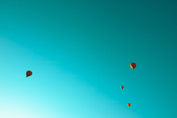 Hot air balloons on the turquoise sky at sunrise
