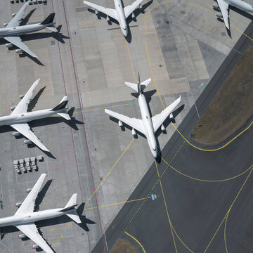 View from above airplanes on sunny airport tarmac and runway
