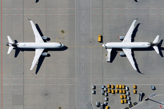 View from above airplanes parked face to face on sunny airport tarmac

