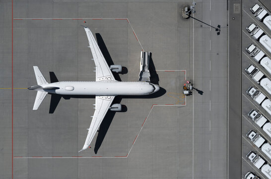 View from above airplane and boarding stairs on sunny airport tarmac
