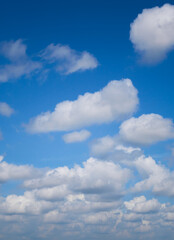 White cumulus clouds forming on vivid blue sky