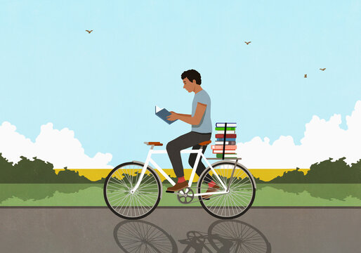 Man with stack of books reading and riding bicycle in sunny, idyllic countryside

