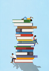Young man and women reading among tall stack of books
