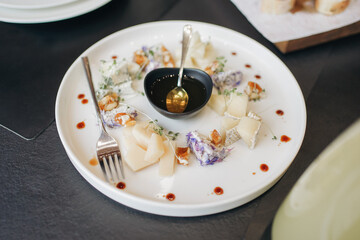 A plate with cheese and honey on the festive table.