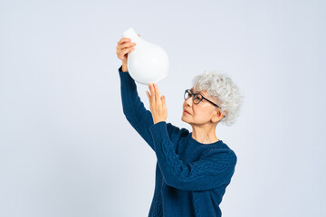 磁器の壺を鑑定するシニア女性 © metamorworks