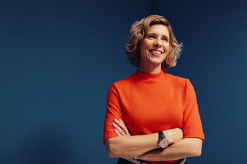 Confident mature businesswoman in vibrant colorblocking portrait with a blue and orange monochromatic set