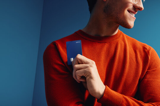 Man holding bank card in vibrant color blocking studio shot