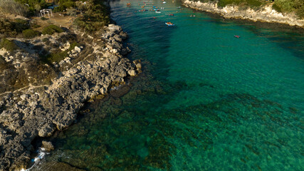 Aerial view of people bathing in the sea in Puglia, Italy. The coast is rocky in this part of the Mediterranean.