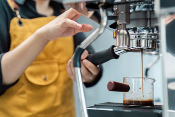 Barista Preparing Fresh Espresso with Professional Coffee Machine in Modern Cafe