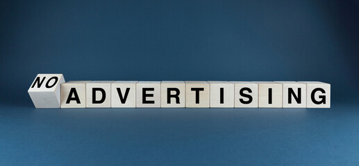 Wooden blocks spelling out Advertising before being flipped to reveal No Advertising