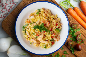 Couscous salad with vegetables and prawns. Top view table with  decoration.