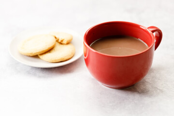 Red cup of delicious hot chocolate on white table background.