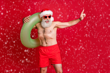 Portrait of his he nice attractive positive cheerful muscular gray-haired man carrying pond circle summertime leisure having fun rest relax poolside isolated over bright vivid shine red background