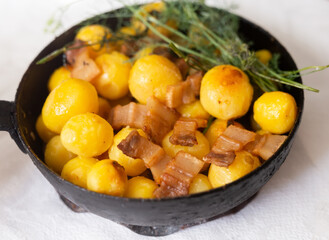 Young potatoes with pork belly fried in frying pan