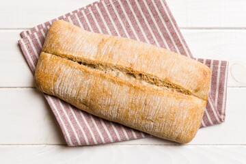 Fresh ciabatta bread on napkin on rustic background, Italian bread top view