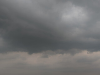 Obraz premium Dark, looming storm clouds dominate the sky, creating a moody, dramatic atmosphere. The overcast sky hints at an impending rainstorm, with thick clouds rolling in and covering the horizon.