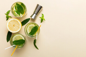 Caipirinha, Mojito cocktail, vodka or soda drink with lime, mint and straw on table background. Refreshing beverage with mint and lime in glass top view flat lay