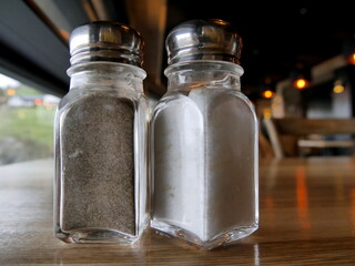 Salt and pepper shakers on table, table seasonings in restaurant