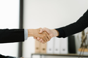 Sealed Deal: A Close-up of a Business Handshake.  Image depicts two businesspeople shaking hands,...