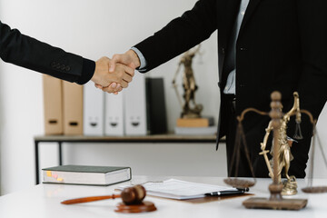 Legal Partnership Sealed: A close-up shot of two lawyers shaking hands, symbolizing a successful legal agreement.  The scene is set in a law office, with legal documents, a gavel.