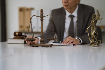 Justice Scales and Legal Counsel: A discerning lawyer thoughtfully considers a case, with scales of justice and a statue of Lady Justice prominently displayed on a pristine desk.