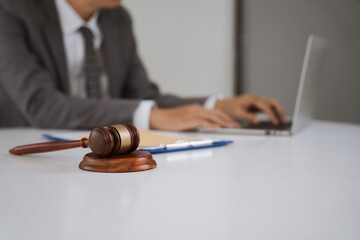Justice in the Digital Age: A lawyer works diligently on a laptop, with a judge's gavel subtly in...
