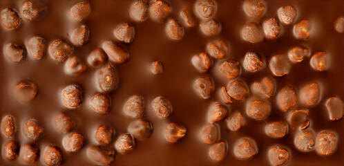 Chocolate bar with hazelnuts texture background. Dark chocolate with nuts. Wallpaper, Pattern