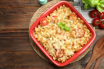 Delicious al forno pasta in baking dish on wooden table, flat lay