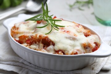 Delicious al forno pasta in baking dish on light table, closeup