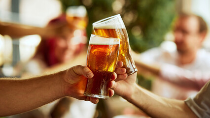 Toast to victory. Fans celebrate with their beers, blurred crowd behind them buzzing with shared emotion and energy. Selective focus. Concept of Oktoberfest, brewery, vacation, Friday mood.