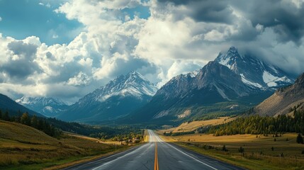 Naklejka premium A highway running along the base of a mountain range, with dramatic cloud formations gathering over the peaks.