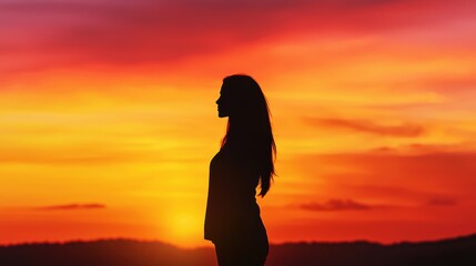 Strong Woman Silhouette Against Vibrant Sunset Sky