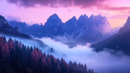 Obraz premium Majestic mountain range with pink and purple clouds and mist in the valley.