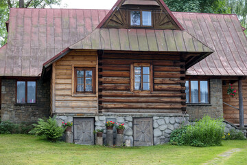 
an old wooden house in the village with cut grass in front