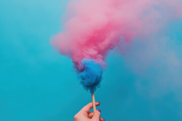 A close-up of a hand holding a gender reveal smoke bomb with pink and blue smoke on a blank background, leaving room for text, perfect for commercial use. The dynamic colors are highlighted.