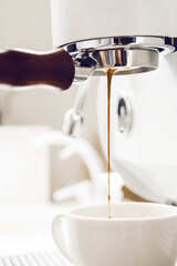 Making espresso on coffee machine through bare portafilter with excellent crema. Espresso flowing through bottomless portafilter