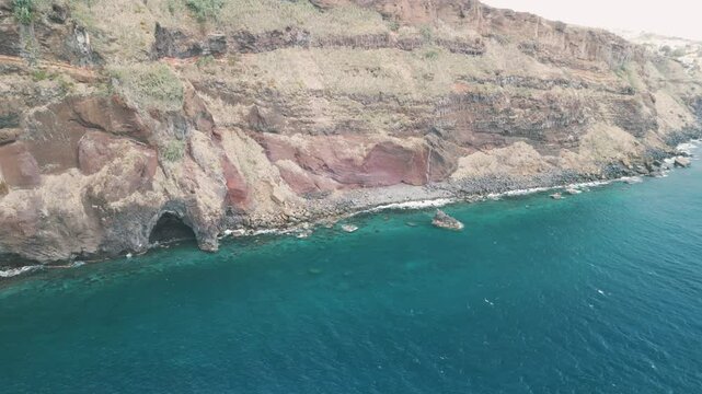 Atlantic waves crashing against the rocky coast of the Portuguese island of Madeira near Christo Rei, Canico. Drone aerial video.