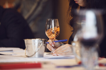 Close-up Swirling Rose Wine in Glass. Sommelier Tasting Event.