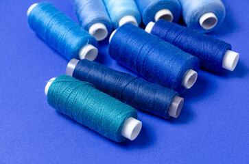 Top view of thread spools on blue background