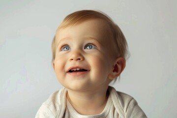Fototapeta premium A little one gazes upward, big blue eyes shining bright