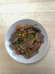 A plate of beef rib stew with carrot and mushroom.