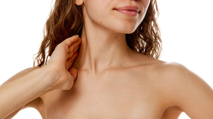 Cropped photo of young woman's neckline with soft, smooth, toned skin against white studio...