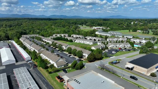 Modern residential area in American city Suburb. Upper class new houses in suburbia of American town. Row of red self storage units and garage in district. Aerial approaching flight.