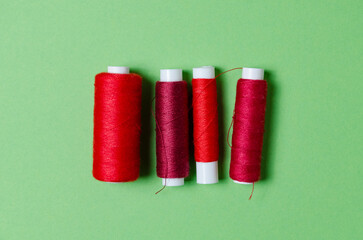 Top view of red thread spools on green background