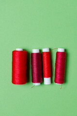 Top view of red thread spools on green background