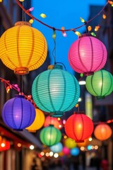 Colorful paper lanterns illuminated at night create a vibrant atmosphere in a festive street setting.